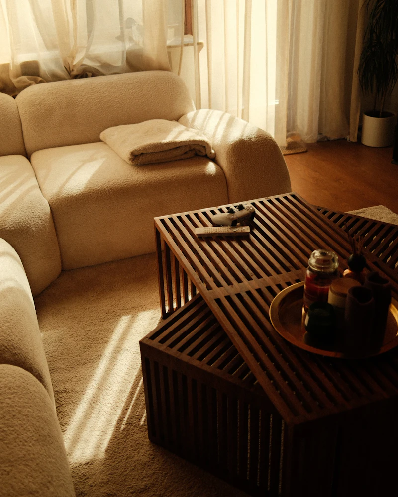 Cream bouclé sofa and slatted walnut coffee table in golden evening light