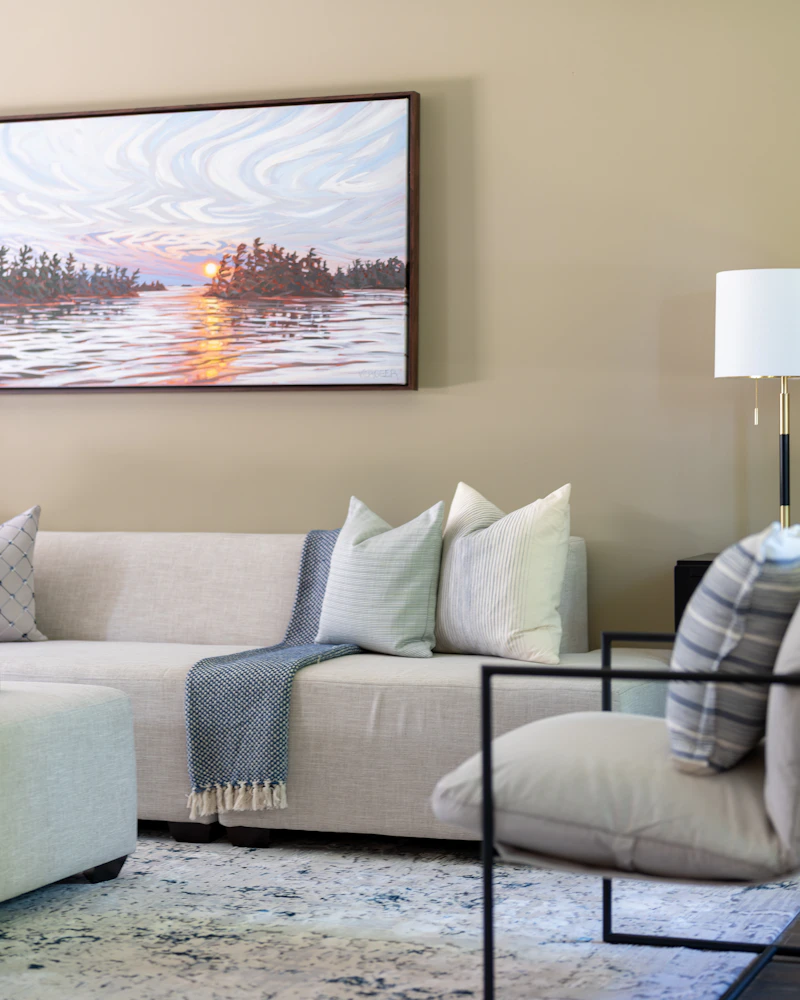 Living room in warm beige with linen sectional and lakeside painting